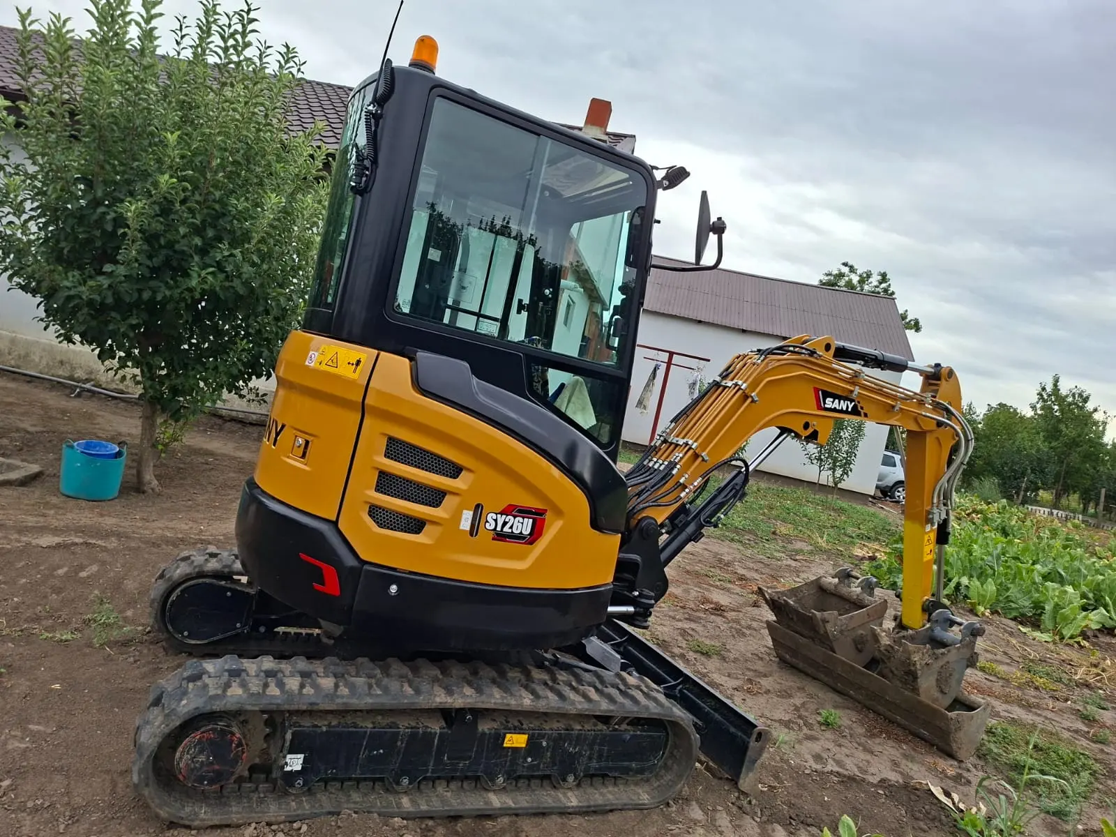 Miniexcavator SANY propriu, pregătit pentru o lucrare de demolare și curățare a terenului.